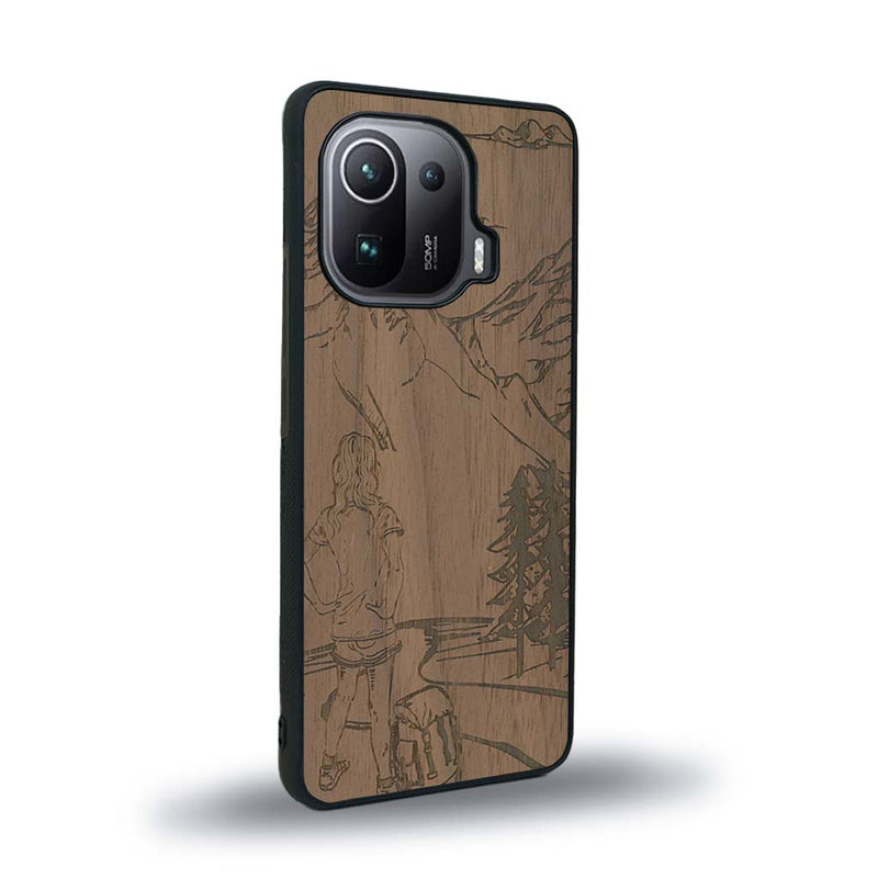 Coque de protection en bois véritable fabriquée en France pour Xiaomi Mi 11 Ultra sur le thème de la randonnée en montagne et de l'aventure avec une gravure représentant une femme de dos face à un paysage de nature