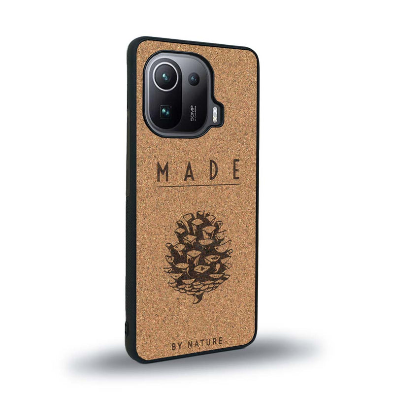 Coque de protection en bois véritable fabriquée en France pour Xiaomi Mi 11 Ultra sur le thème de la nature et des arbres avec une gravure représentant une pomme de pin et la phrase "made by nature"