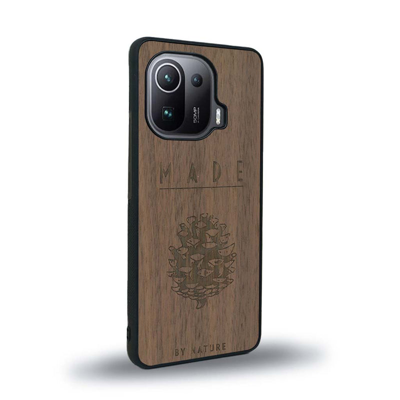 Coque de protection en bois véritable fabriquée en France pour Xiaomi Mi 11 Ultra sur le thème de la nature et des arbres avec une gravure représentant une pomme de pin et la phrase "made by nature"