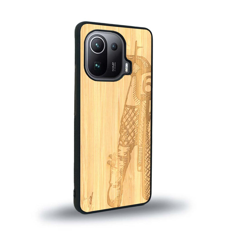 Coque de protection en bois véritable fabriquée en France pour Xiaomi Mi 11 Ultra représentant une vue de face d'une femme sur une moto vintage dessinée à la main par l'artiste Maud Dabs