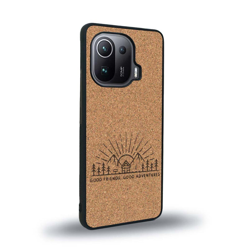 Coque de protection en bois véritable fabriquée en France pour Xiaomi Mi 11 Ultra sur le thème chill et nature avec un motif représentant un levé de soleil sur un paysage de montagne avec des sapins et un chalet et la phrase "Good friends, good adventure"