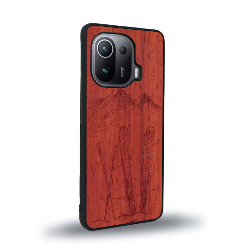 Coque de protection en bois véritable fabriquée en France pour Xiaomi Mi 11 Ultra sur le thème de la montagne, du ski et de la neige avec un motif représentant une paire de ski plantée dans la neige avec en fond des montagnes enneigées