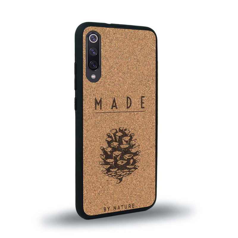 Coque de protection en bois véritable fabriquée en France pour Xiaomi Mi 9SE sur le thème de la nature et des arbres avec une gravure représentant une pomme de pin et la phrase "made by nature"