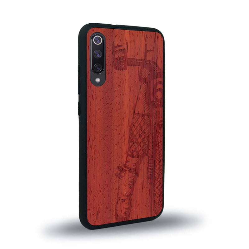 Coque de protection en bois véritable fabriquée en France pour Xiaomi Mi 9SE représentant une vue de face d'une femme sur une moto vintage dessinée à la main par l'artiste Maud Dabs