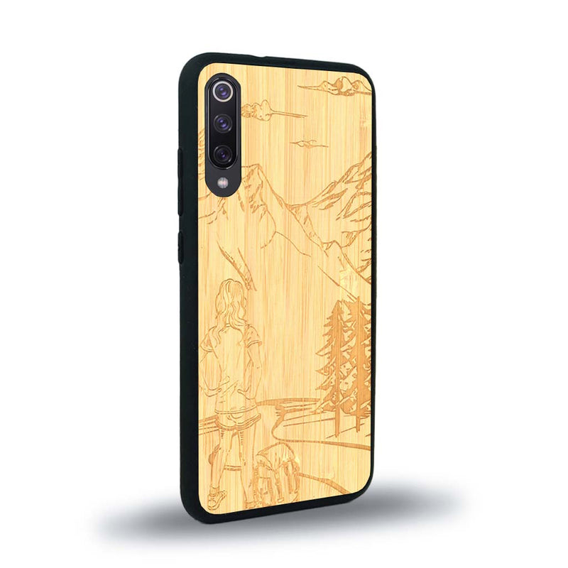 Coque de protection en bois véritable fabriquée en France pour Xiaomi Mi A3 sur le thème de la randonnée en montagne et de l'aventure avec une gravure représentant une femme de dos face à un paysage de nature