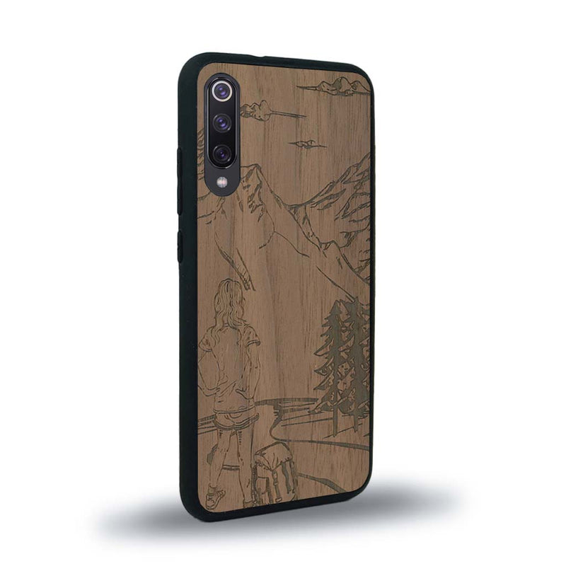 Coque de protection en bois véritable fabriquée en France pour Xiaomi Mi A3 sur le thème de la randonnée en montagne et de l'aventure avec une gravure représentant une femme de dos face à un paysage de nature