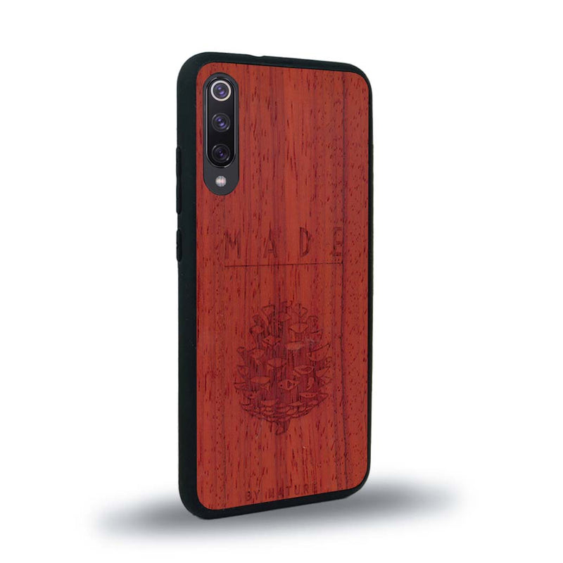 Coque de protection en bois véritable fabriquée en France pour Xiaomi Mi Note 10 Lite sur le thème de la nature et des arbres avec une gravure représentant une pomme de pin et la phrase "made by nature"