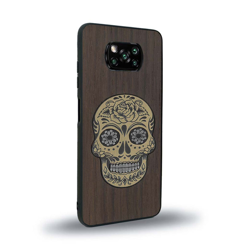 Coque de protection en bois véritable fabriquée en France pour Xiaomi Poco X3 Nfc alliant du chêne fumé avec du métal argenté et doré représentant une tête de mort mexicaine sur le thème Dia de los Muertos