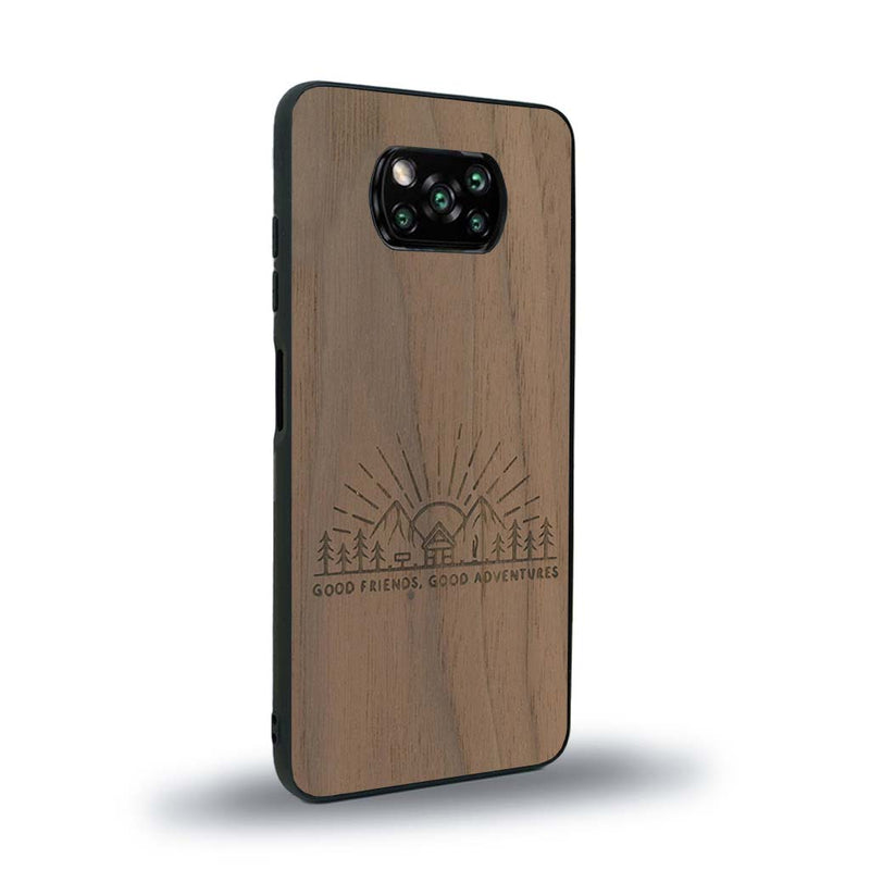 Coque de protection en bois véritable fabriquée en France pour Xiaomi Poco X3 Nfc sur le thème chill et nature avec un motif représentant un levé de soleil sur un paysage de montagne avec des sapins et un chalet et la phrase "Good friends, good adventure"