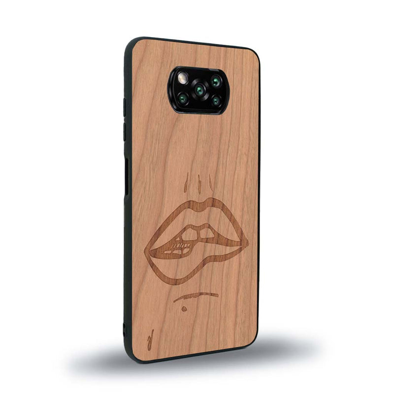 Coque de protection en bois véritable fabriquée en France pour Xiaomi Poco X3 Nfc représentant de manière minimaliste une bouche de féminine se mordant le coin de la lèvre de manière sensuelle dessinée à la main par l'artiste Maud Dabs