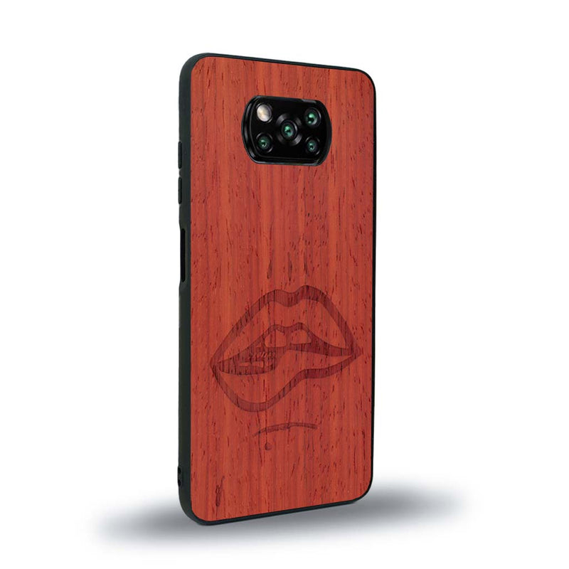 Coque de protection en bois véritable fabriquée en France pour Xiaomi Poco X3 Nfc représentant de manière minimaliste une bouche de féminine se mordant le coin de la lèvre de manière sensuelle dessinée à la main par l'artiste Maud Dabs