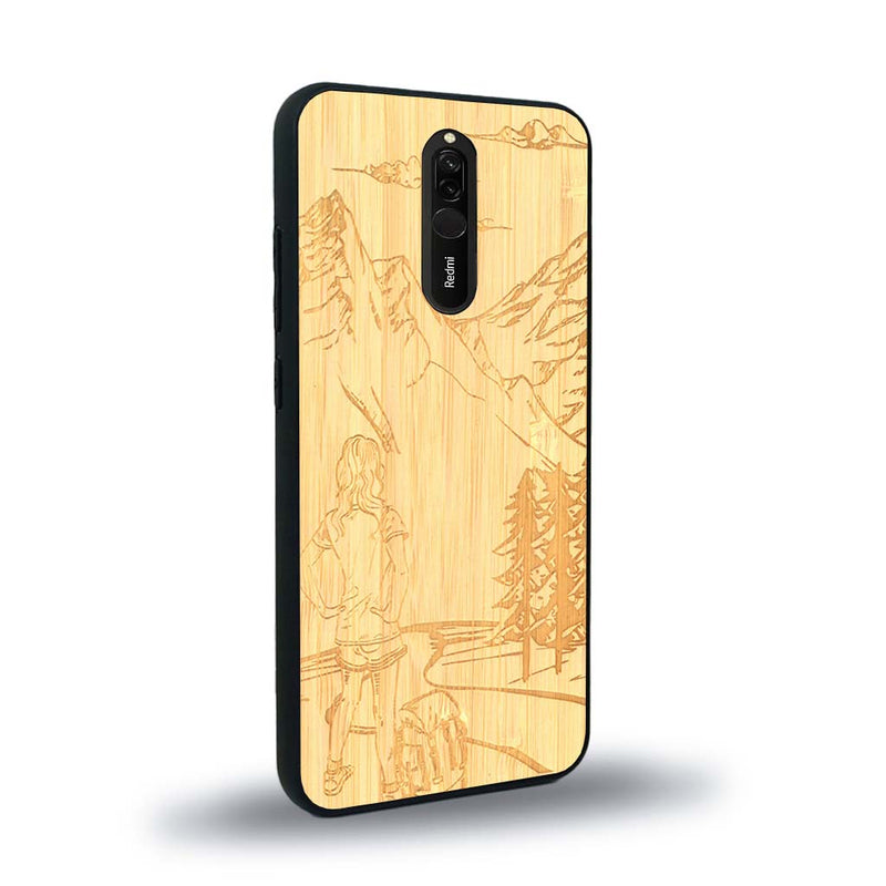 Coque de protection en bois véritable fabriquée en France pour Xiaomi Redmi 8 sur le thème de la randonnée en montagne et de l'aventure avec une gravure représentant une femme de dos face à un paysage de nature