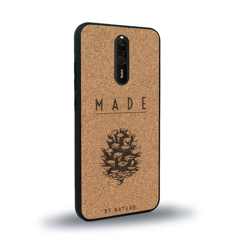 Coque de protection en bois véritable fabriquée en France pour Xiaomi Redmi 8 sur le thème de la nature et des arbres avec une gravure représentant une pomme de pin et la phrase "made by nature"