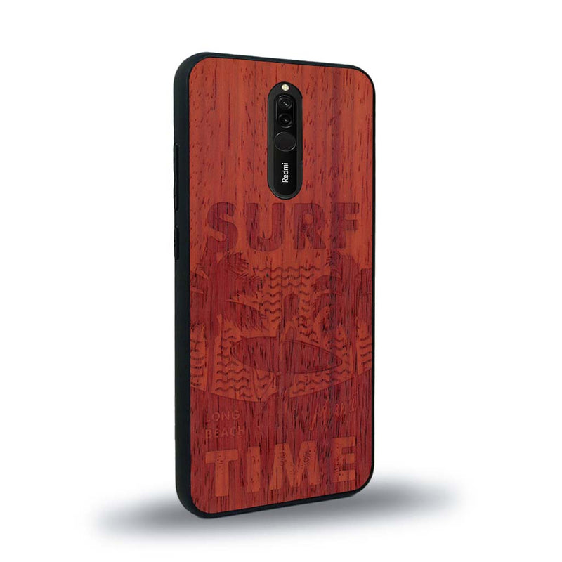 Coque de protection en bois véritable fabriquée en France pour Xiaomi Redmi 8 sur le thème chill avec un motif représentant une silouhette tenant une planche de surf sur une plage entouré de palmiers et les mots "Surf Time Long Beach Miami"