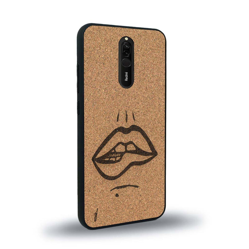 Coque de protection en bois véritable fabriquée en France pour Xiaomi Redmi 8 représentant de manière minimaliste une bouche de féminine se mordant le coin de la lèvre de manière sensuelle dessinée à la main par l'artiste Maud Dabs