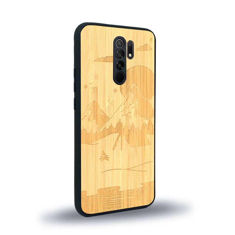 Coque de protection en bois véritable fabriquée en France pour Xiaomi Redmi 9 sur le thème du camping en pleine nature représentant une tente avec un feu de camp entouré de montagnes