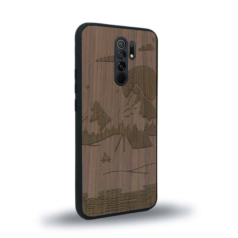 Coque de protection en bois véritable fabriquée en France pour Xiaomi Redmi 9 sur le thème du camping en pleine nature représentant une tente avec un feu de camp entouré de montagnes