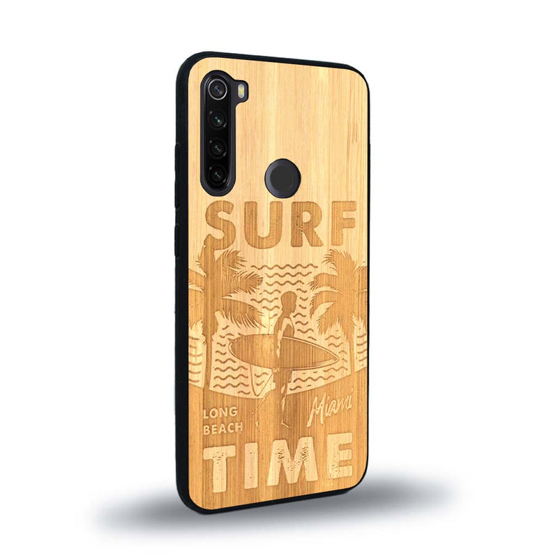 Coque de protection en bois véritable fabriquée en France pour Xiaomi Redmi Note 8T sur le thème chill avec un motif représentant une silouhette tenant une planche de surf sur une plage entouré de palmiers et les mots "Surf Time Long Beach Miami"